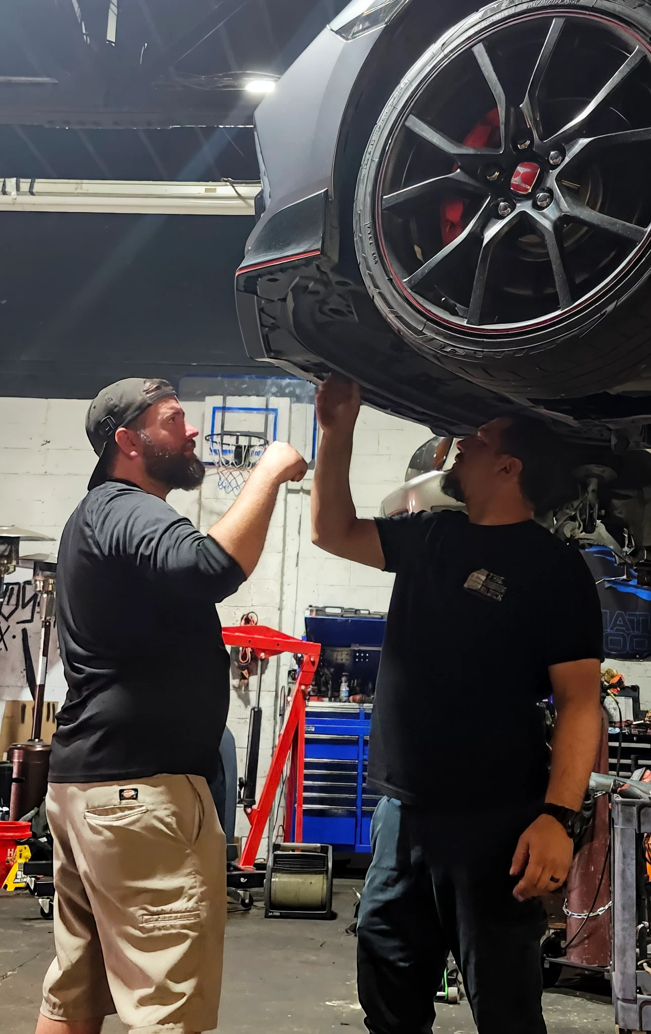 The Engine Block owner Jeff and a customer planning work beneath a Honda Civic Type R on a lift
