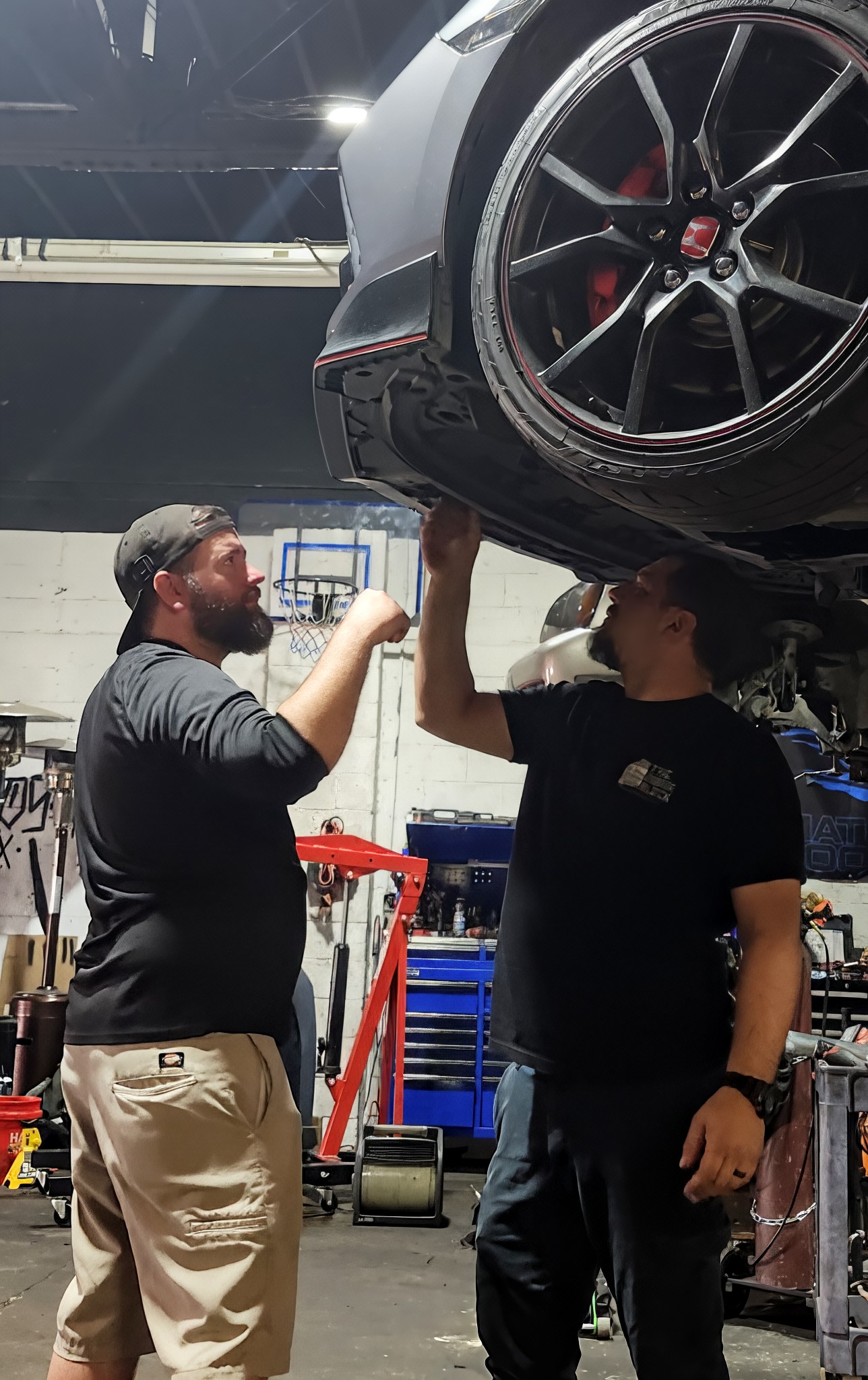 The Engine Block owner Jeff and a customer planning work beneath a Honda Civic Type R on a lift